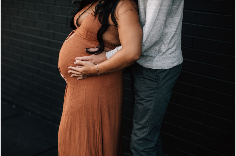 pregnant person with partner holding belly